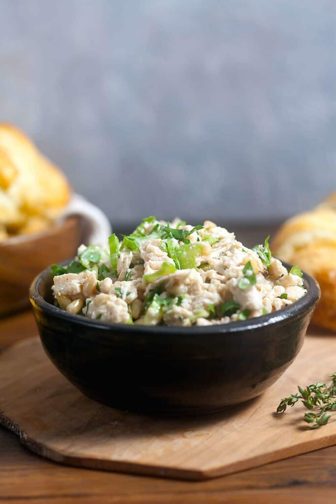 A black pottery bowl filled with mayo-free chicken salad