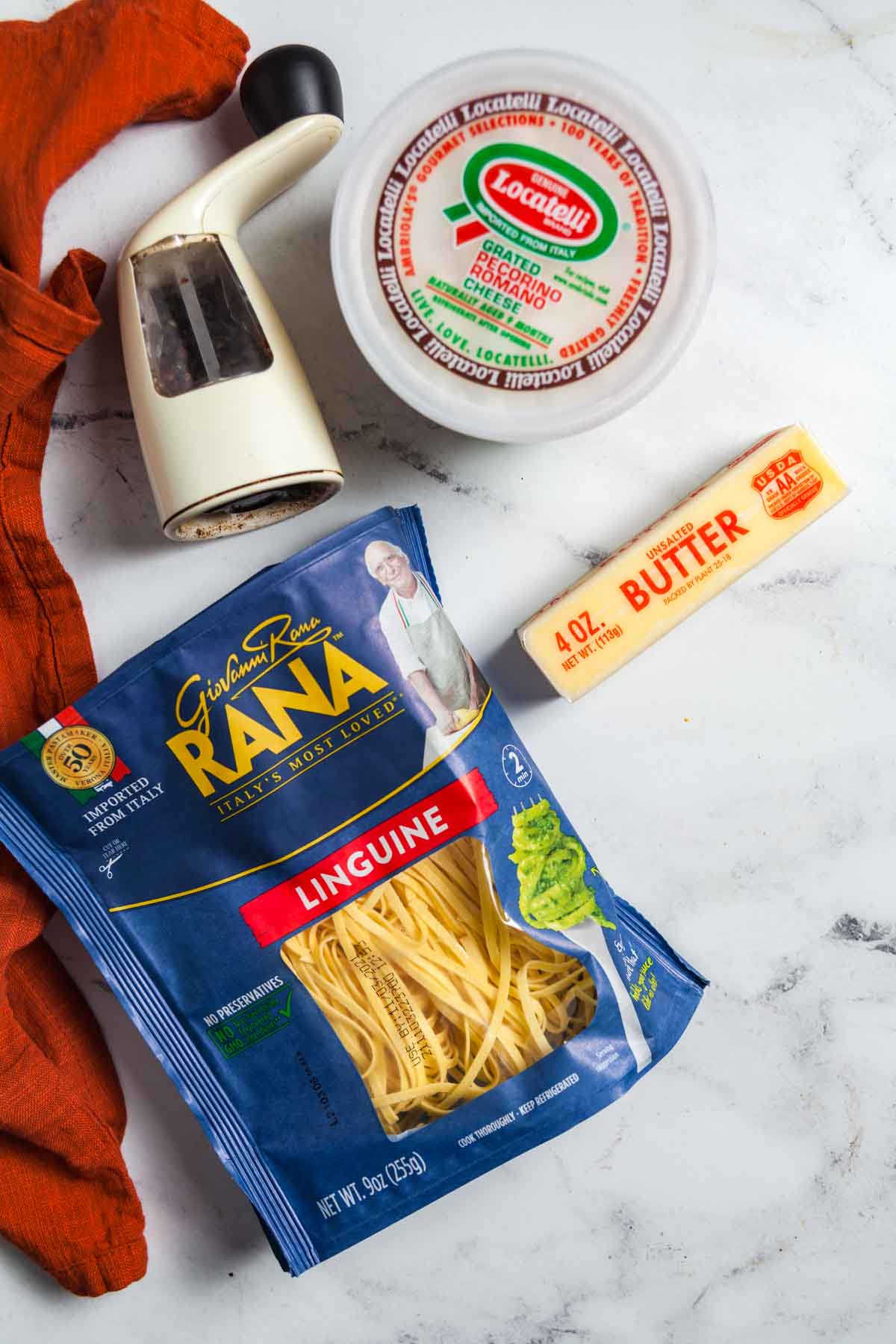 Ingredients for making cacio e pepe with fresh pasta on a marble background.