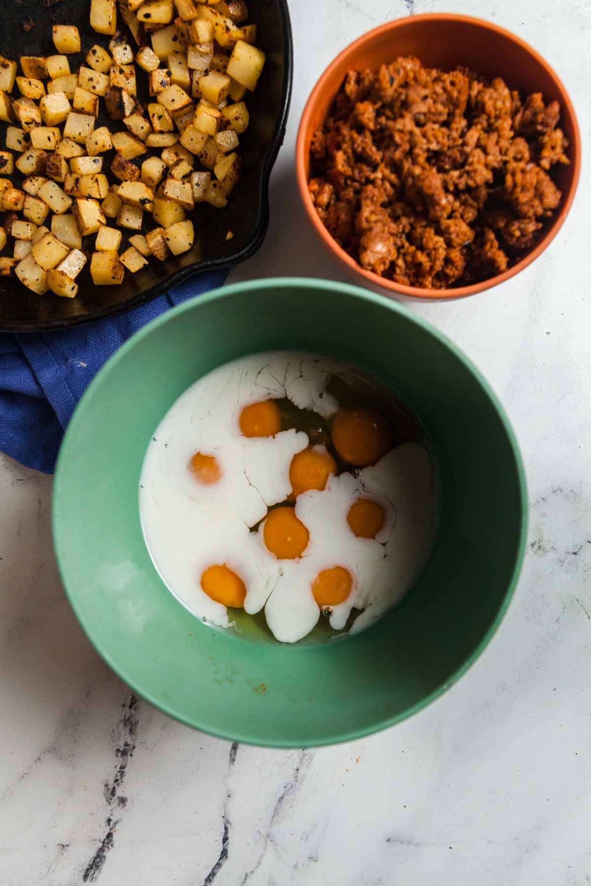 Ingredients for the breakfast scramble: eggs, cream, chorizo, and potatoes.