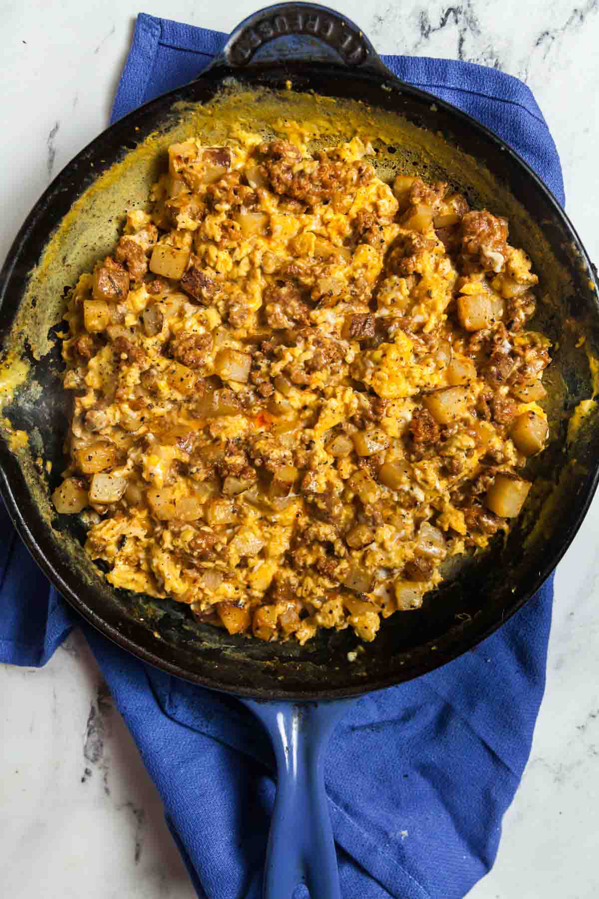 Overhead view of scrambled eggs with chorizo and potatoes for green chile breakfast burritos.