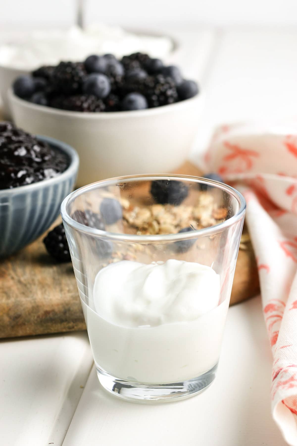 A glass filled one third of the way with yogurt. 