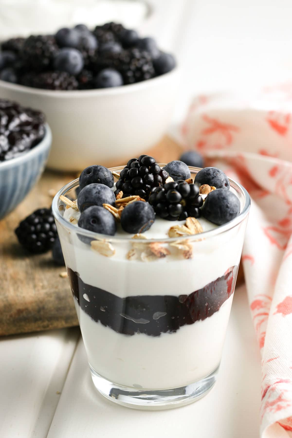 A finished parfait, with layers of yogurt, then jam, then yogurt, then fresh berries and granola. 