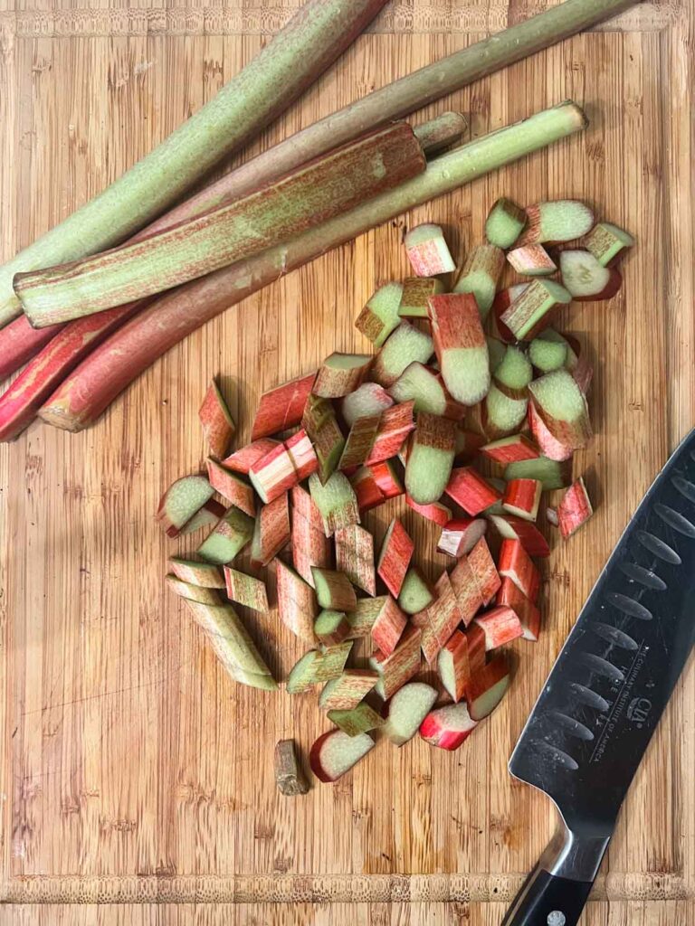 A wooden cutting board with chopped rhubarb.