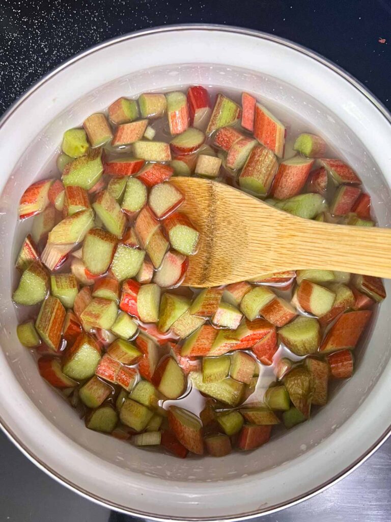 Boiling rhubarb in sugar water to make syrup.