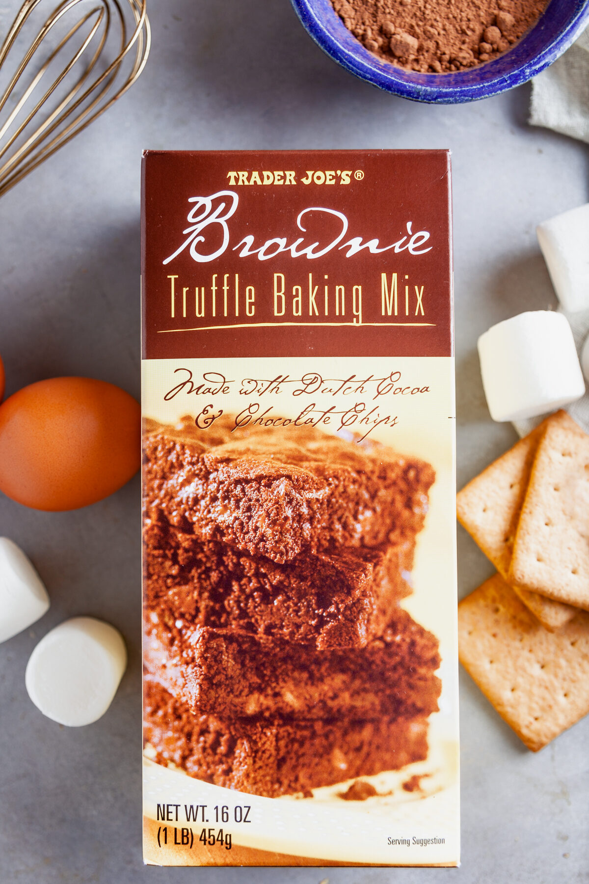 Flat lay image of ingredients needed to make s'mores brownie mix cookies, including a box of Trader Joe's truffle brownie mix. 