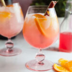 Two spriz cocktails on a white patio table.