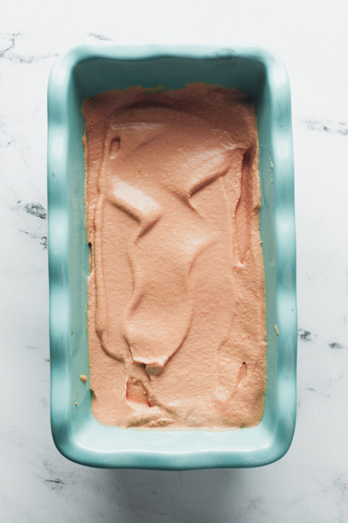 Spreading the ice cream base in a loaf pan before freezing. 