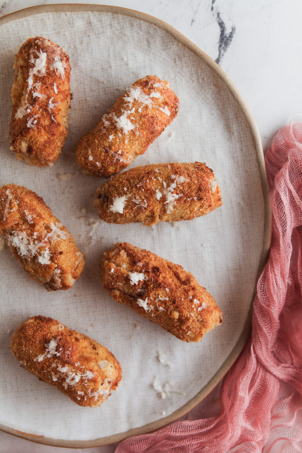 Overhead image of air fryer ham croquettes on a white plate.