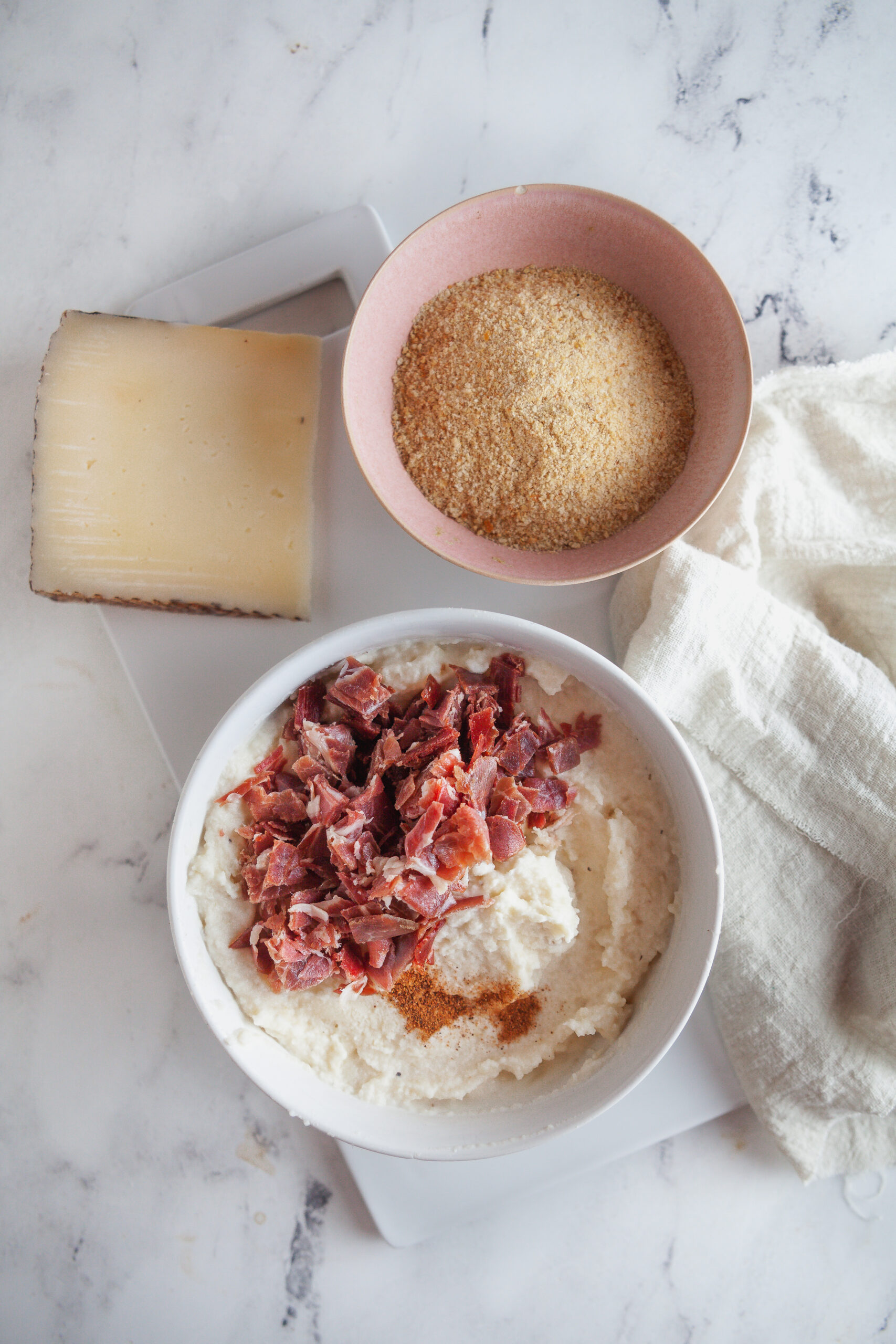 Mixing the jamon and nutmeg into the mashed potatoes.