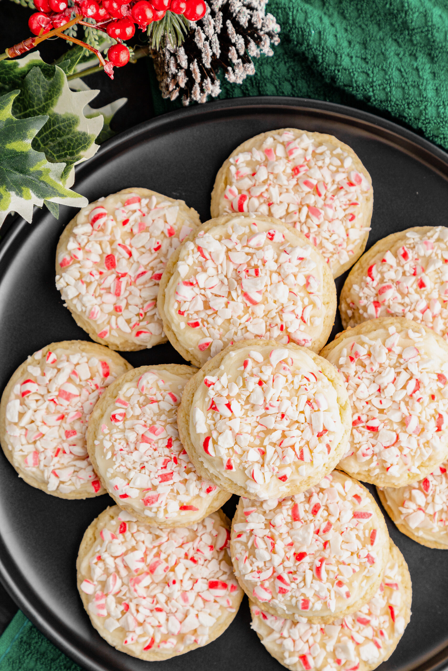 A plate of cake mix cookies with peppermint frosting and candy cane pieces. 