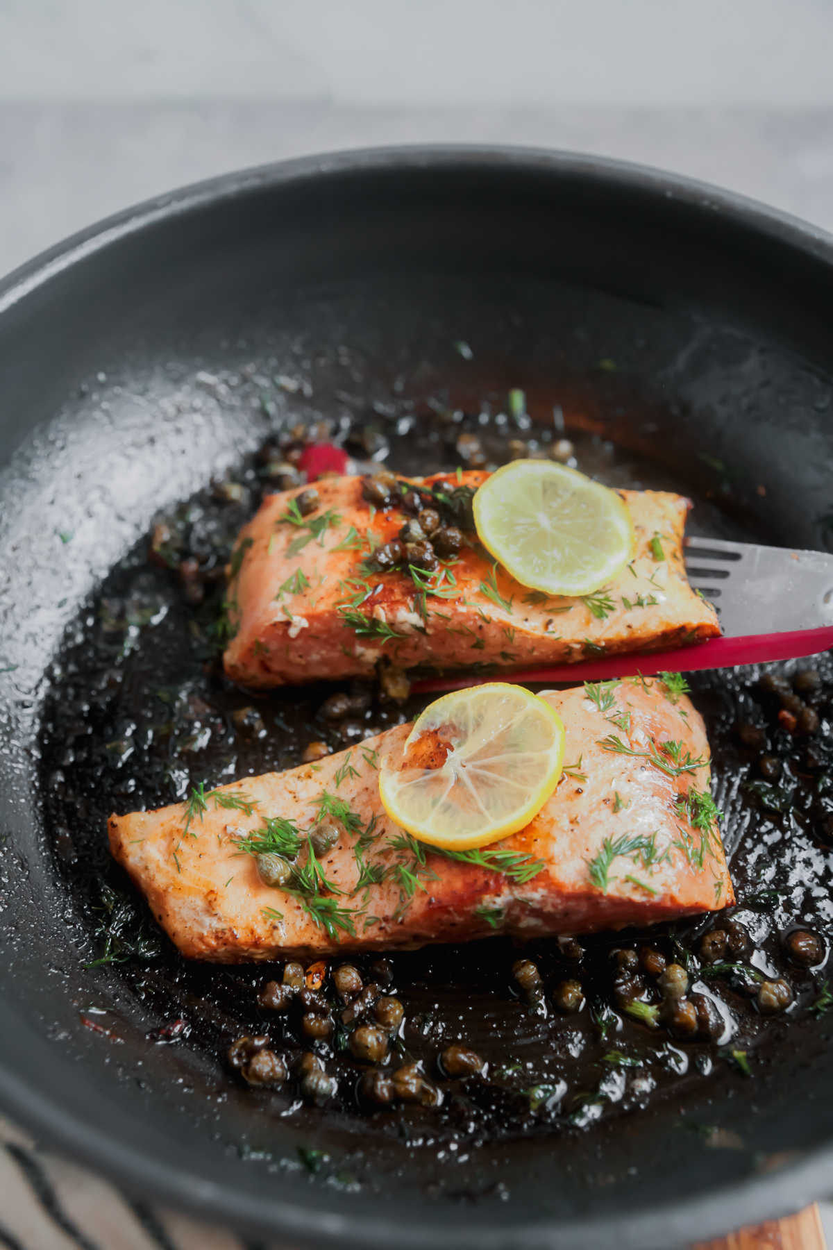 Cooking salmon fillets in a pan.