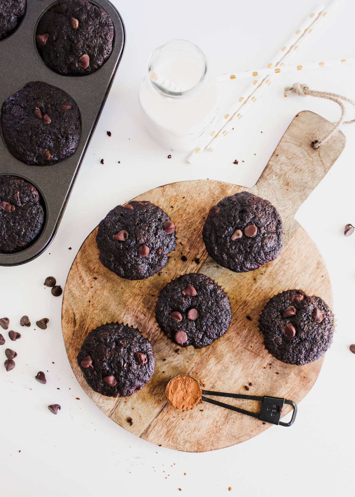 Double chocolate zucchini muffins on a wooden serving board. 