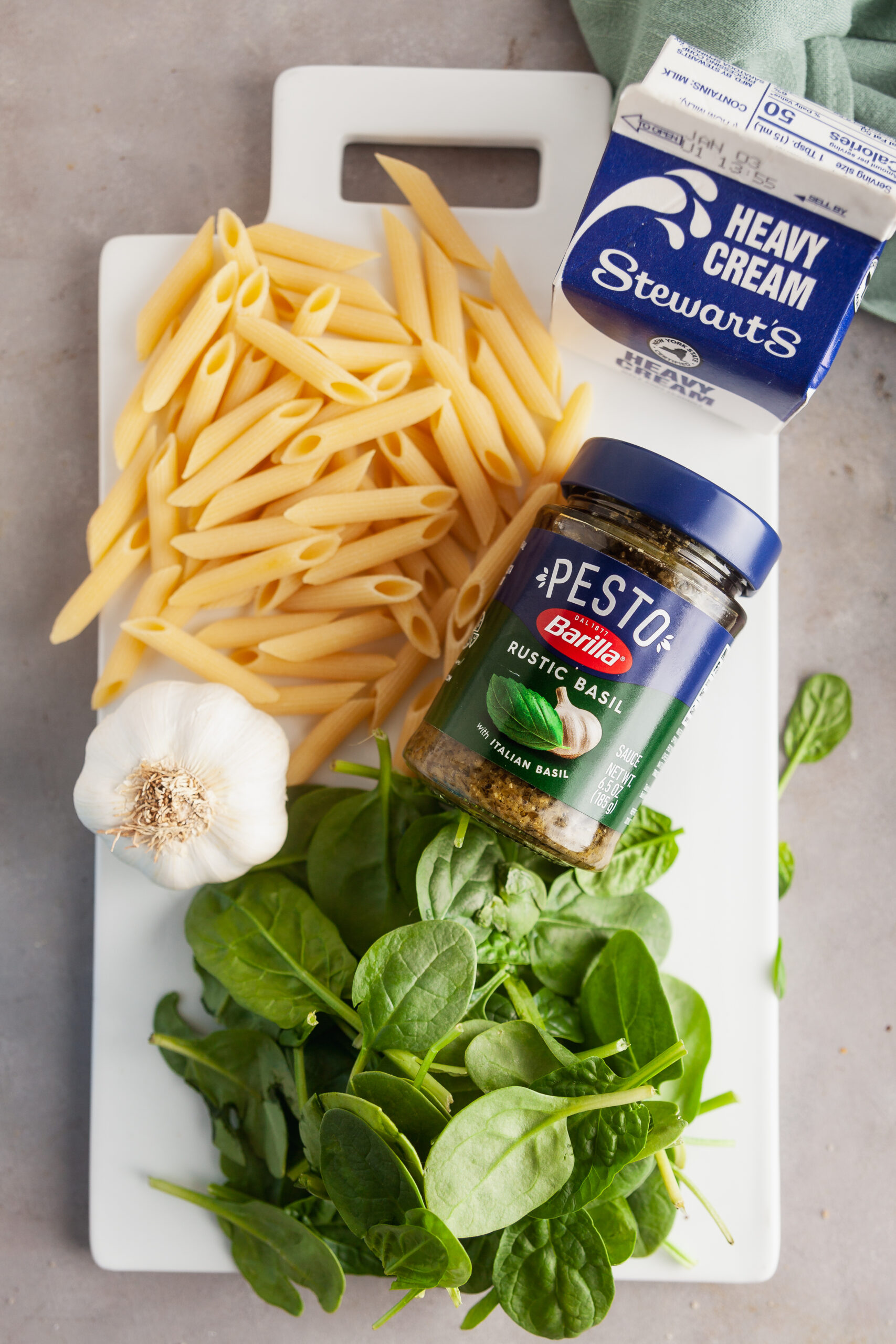 An overhead view of the ingredients needed to make one pot creamy pesto pasta. 