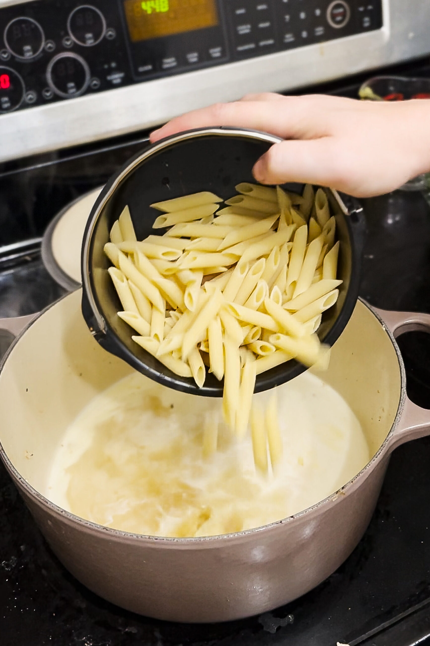 Pouring in the pasta.