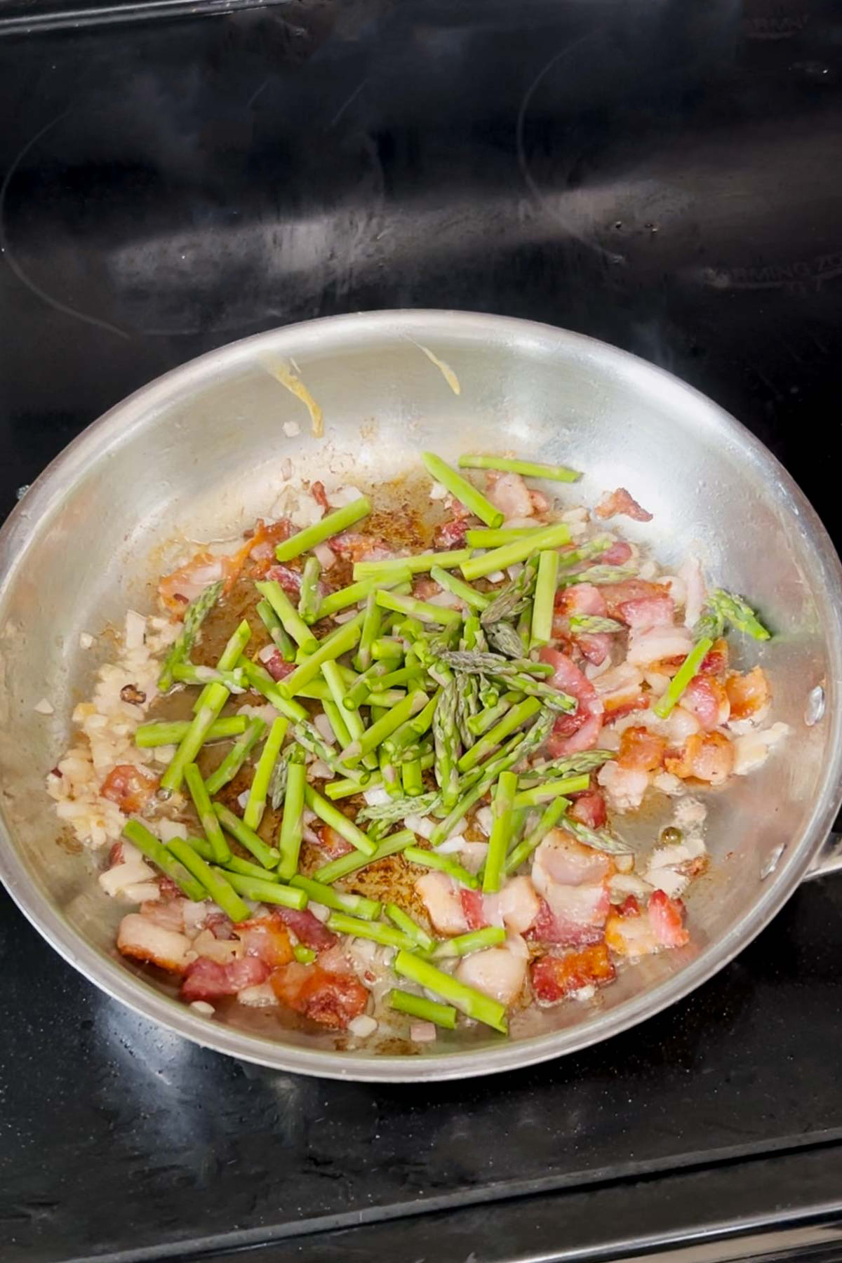 Sautéing the bacon, shallot, and asparagus. 