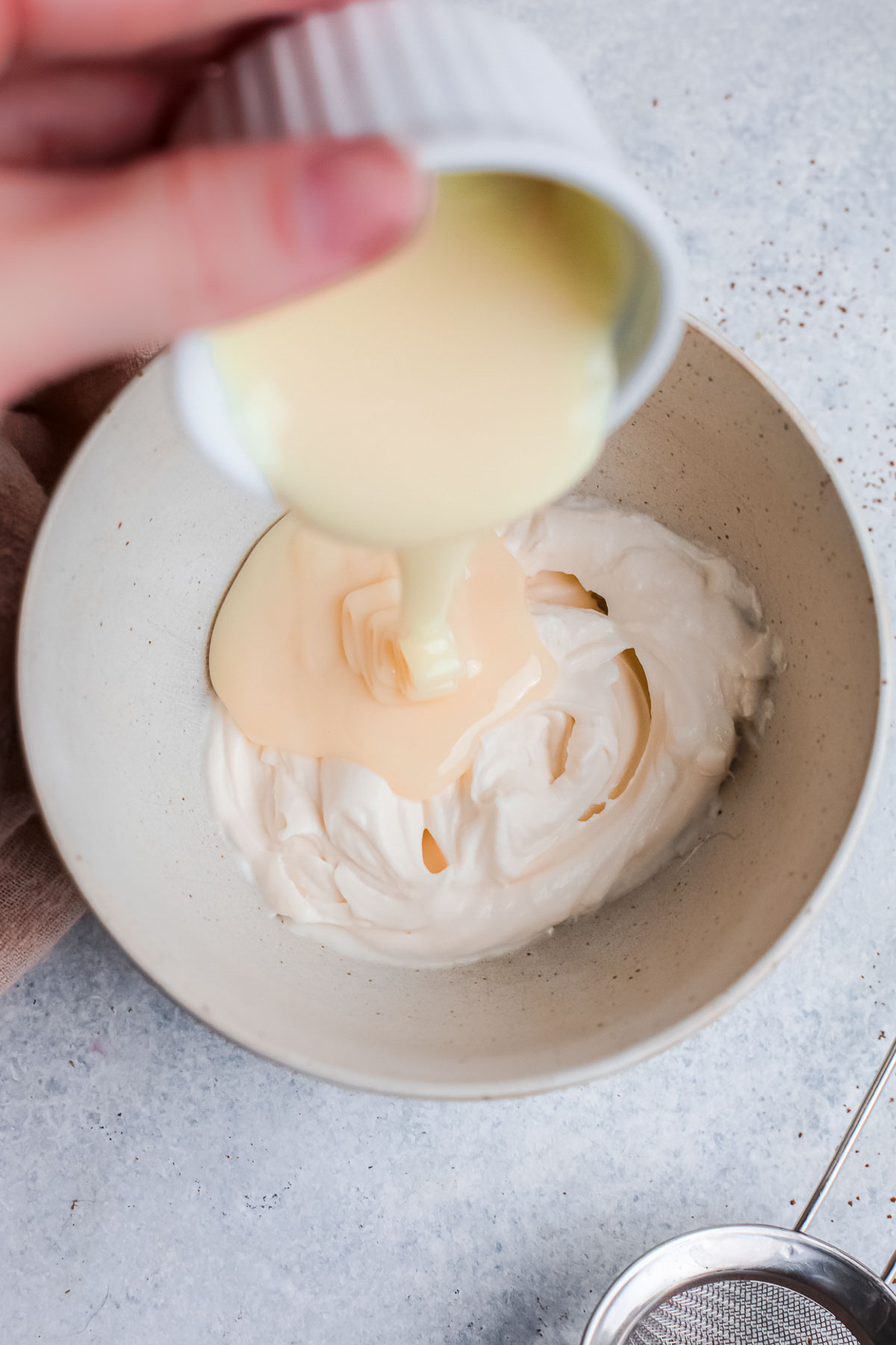 Mixing heavy cream and condensed milk to make homemade cold foam for coffee. 