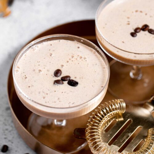 Two eggnog espresso martinis on a serving tray.