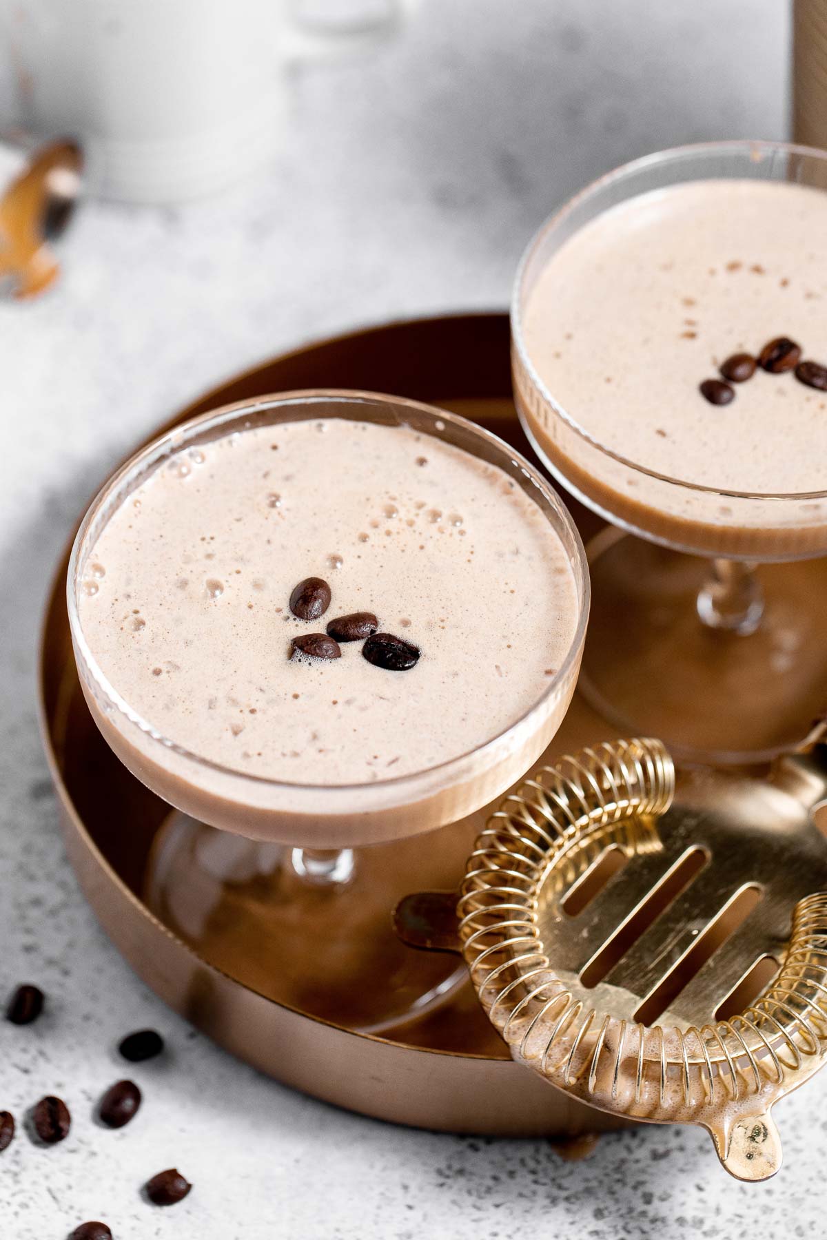 Two eggnog espresso martinis on a serving tray.