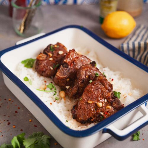 A platter of air fryer lamb loin chops over a bed of rice.