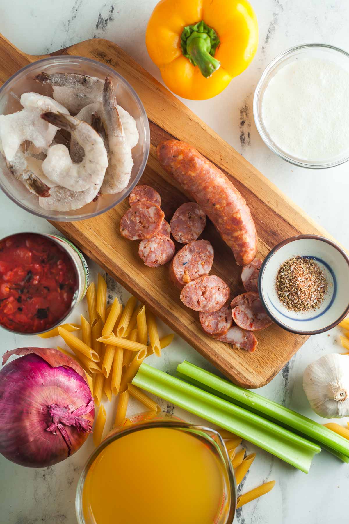 Overhead view of ingredients needed to make creamy jambalaya pasta. 