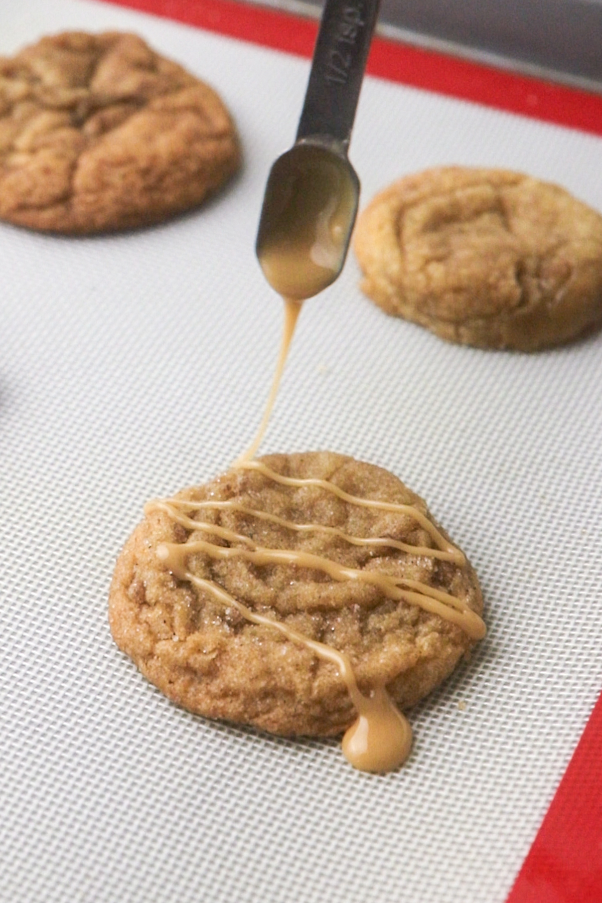 Drizzling the cookies with apple cider glaze.