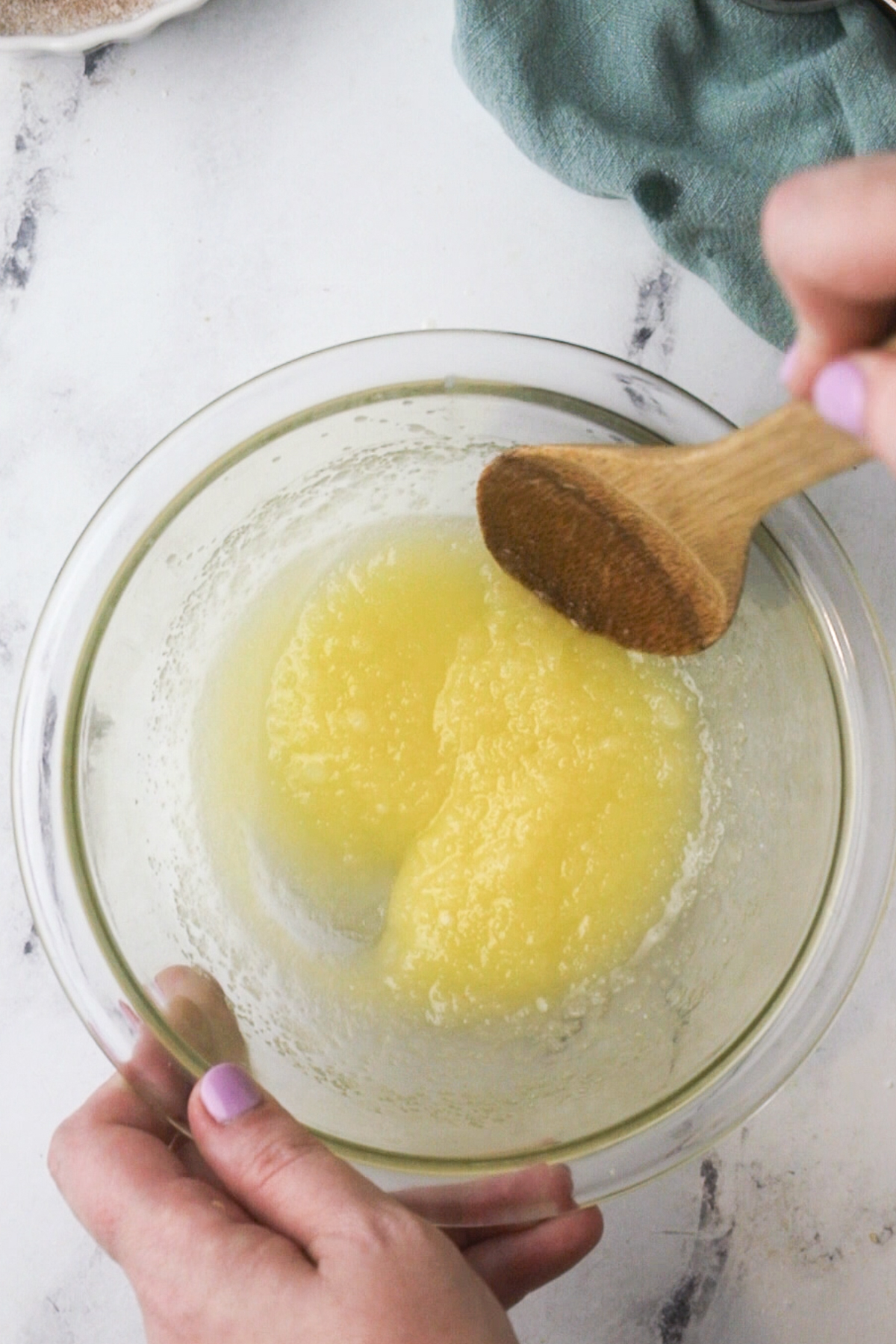 Stirring the sugar into melted butter.