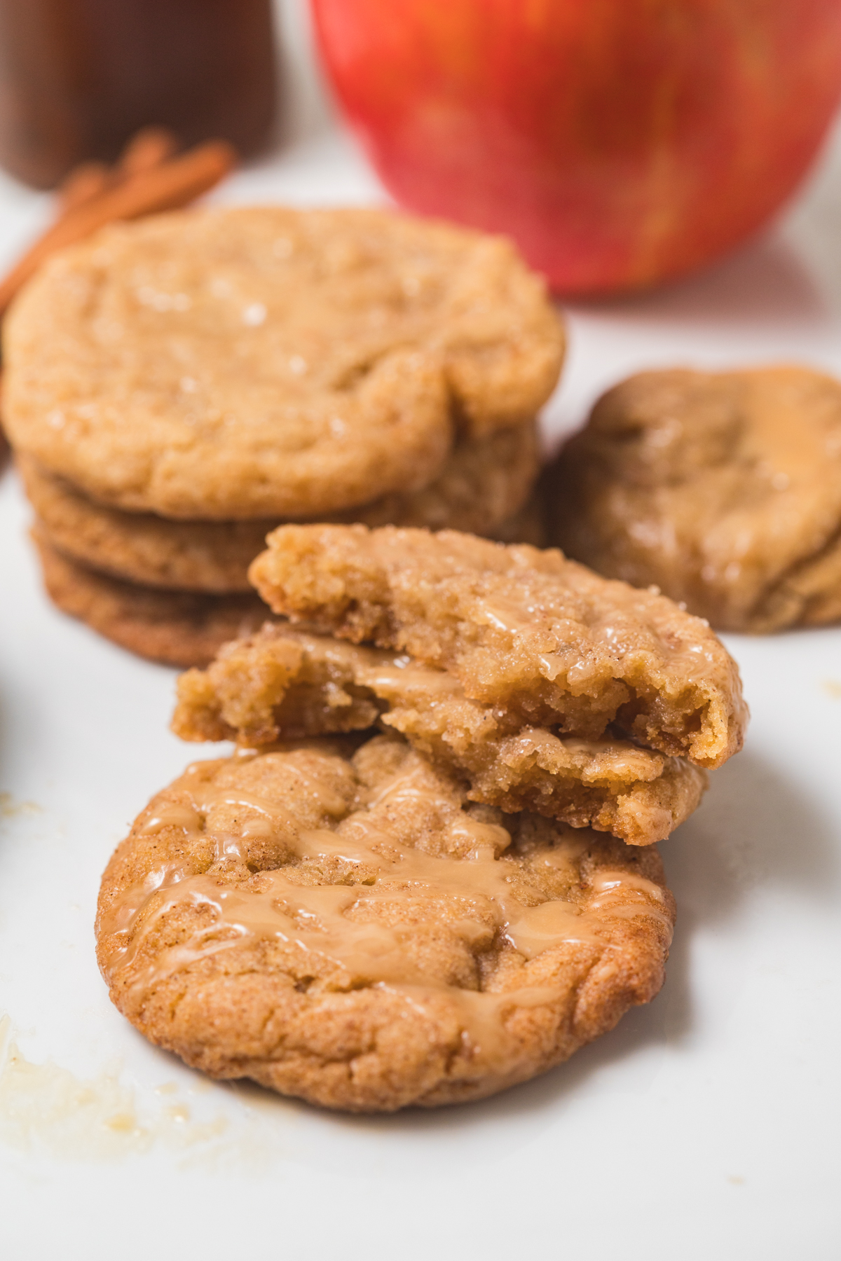 Soft a chewy apple cider sugar cookies - one cookie is cut in half so you can see the texture.