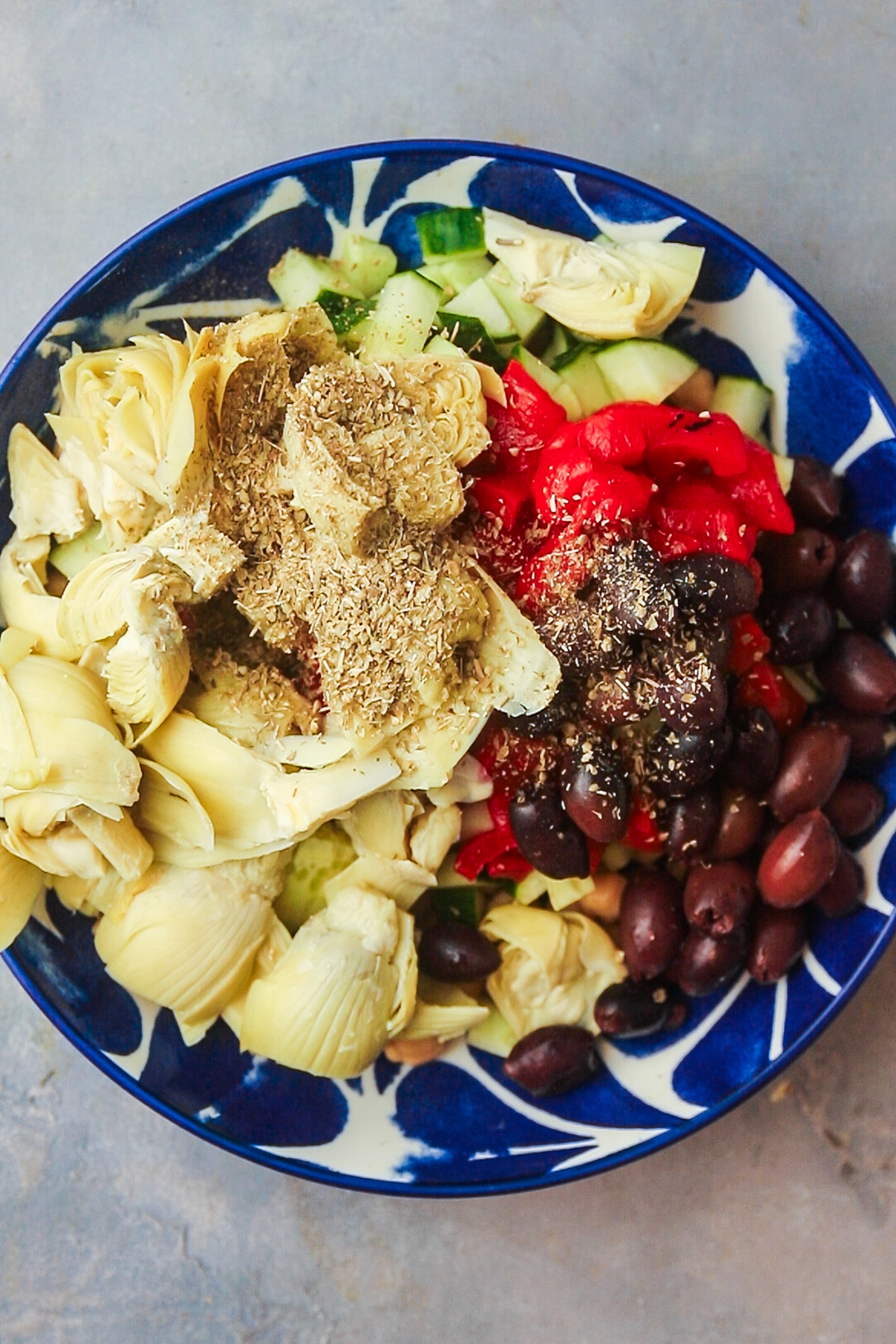 Adding the olives and artichoke hearts and oregano.