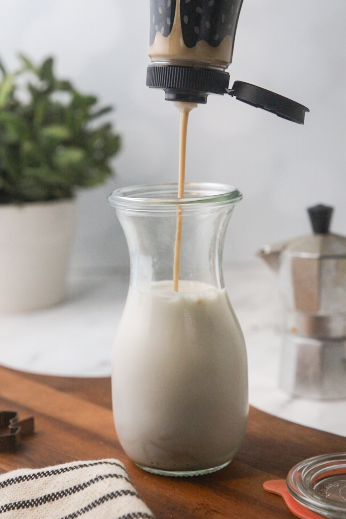 Adding tahini to almond milk.