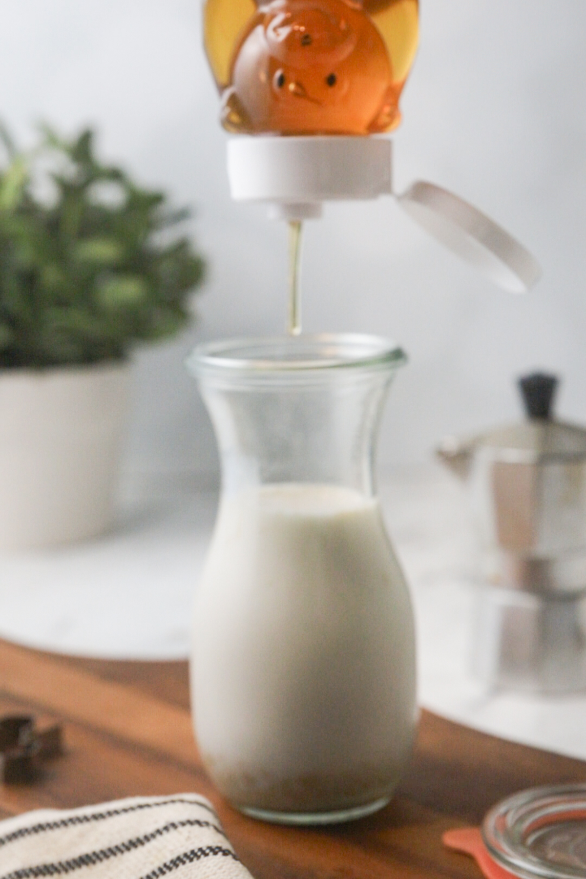 Adding honey to sweeten homemade coffee creamer.