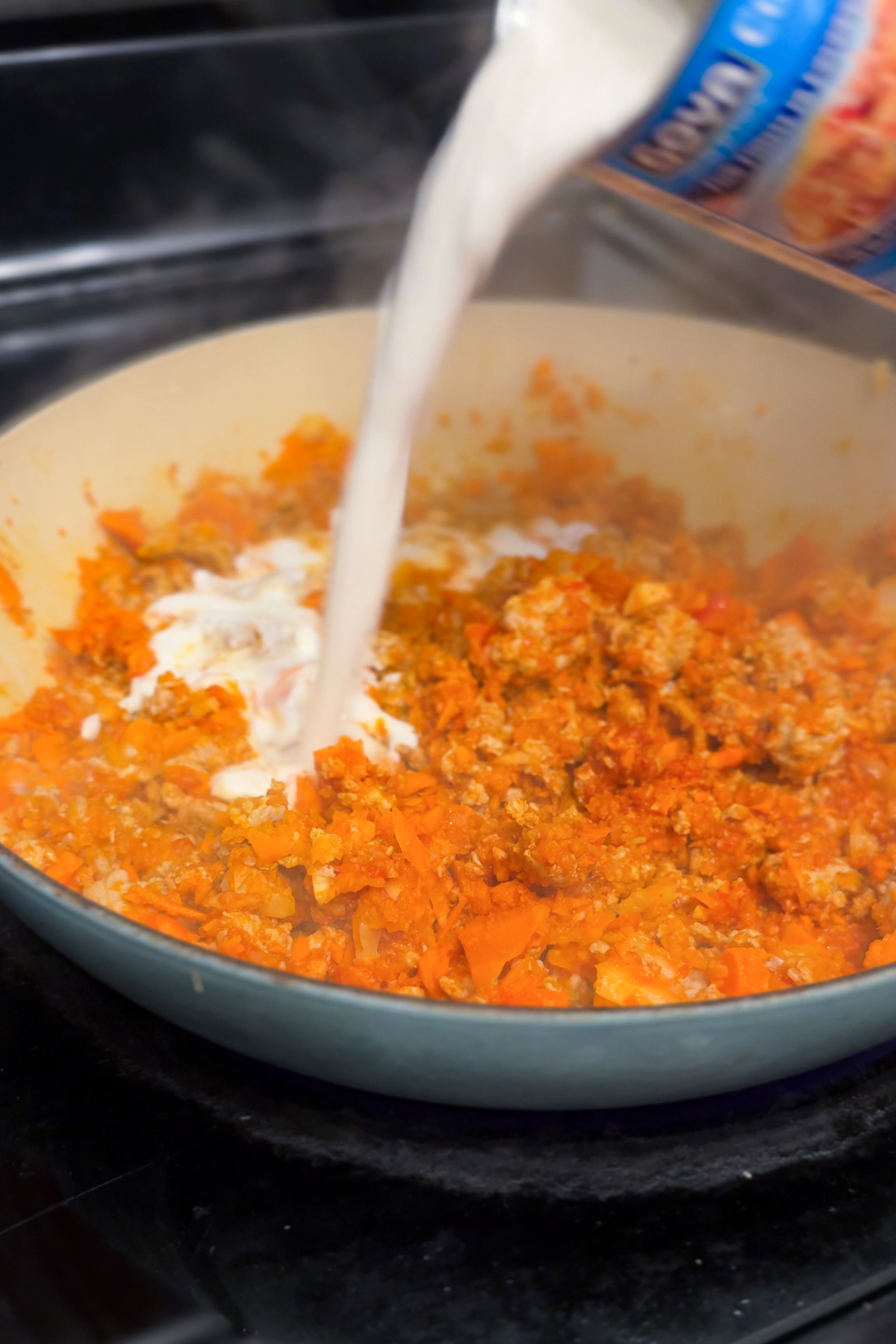 Adding coconut milk to make the sauce creamy. 