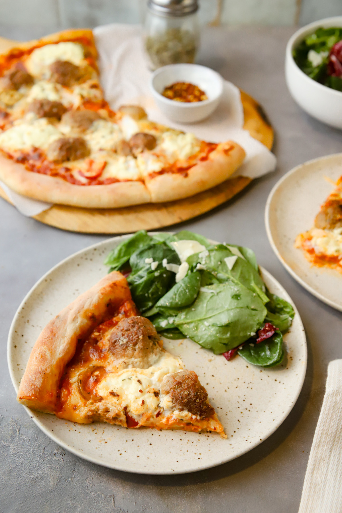 Meatball pizza and salad on a plate. 