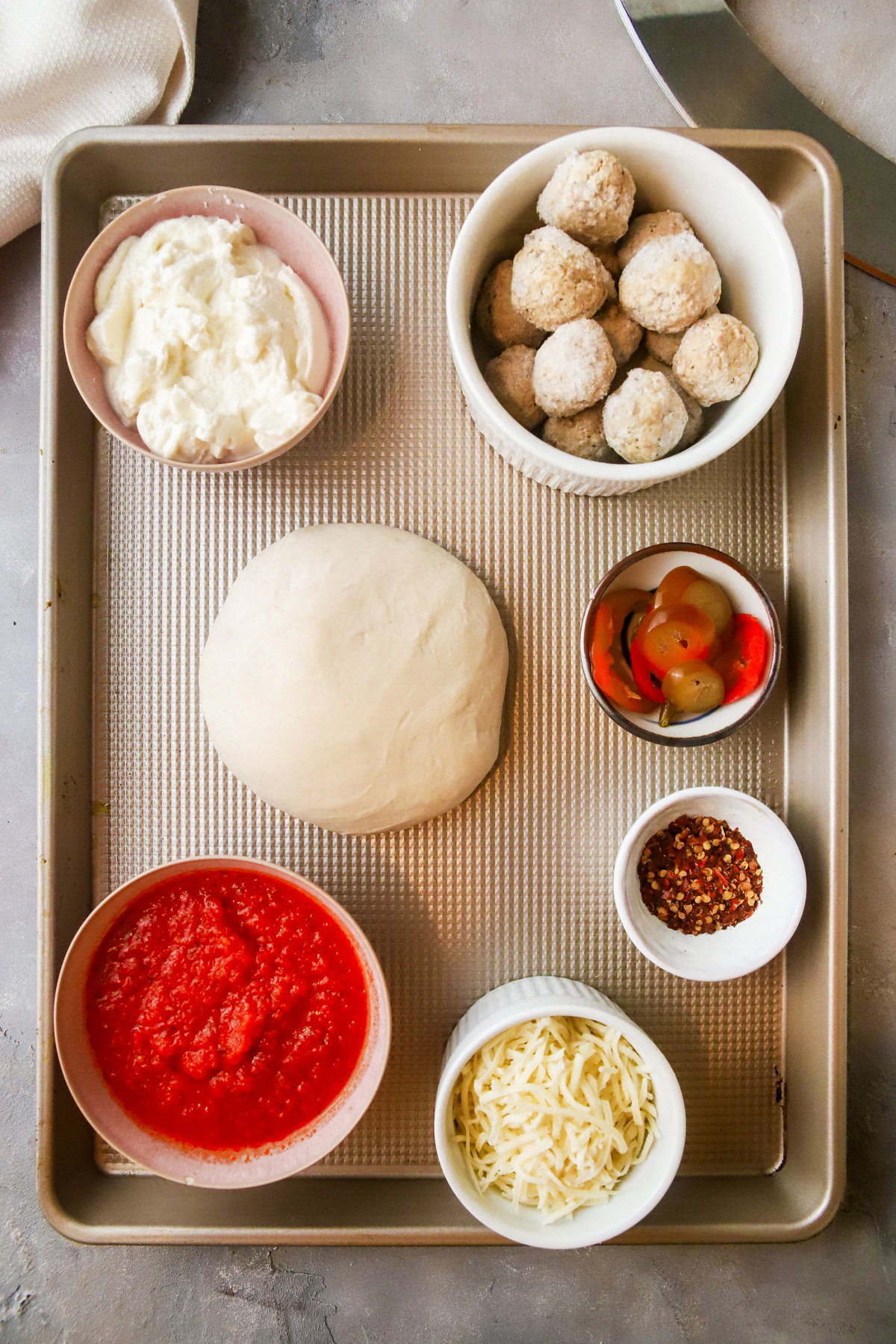 An overhead view of ingredients needed to make pizza using frozen meatballs and ricotta cheese. 