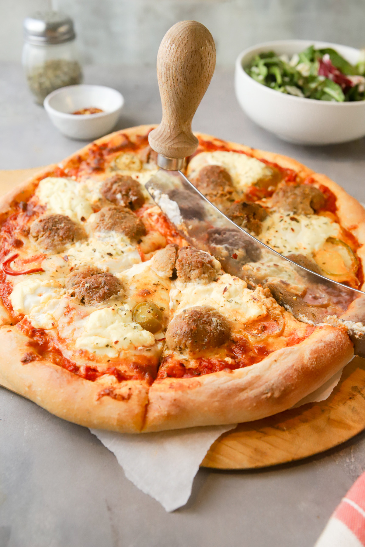 Slicing the pizza with a mezzaluna. 