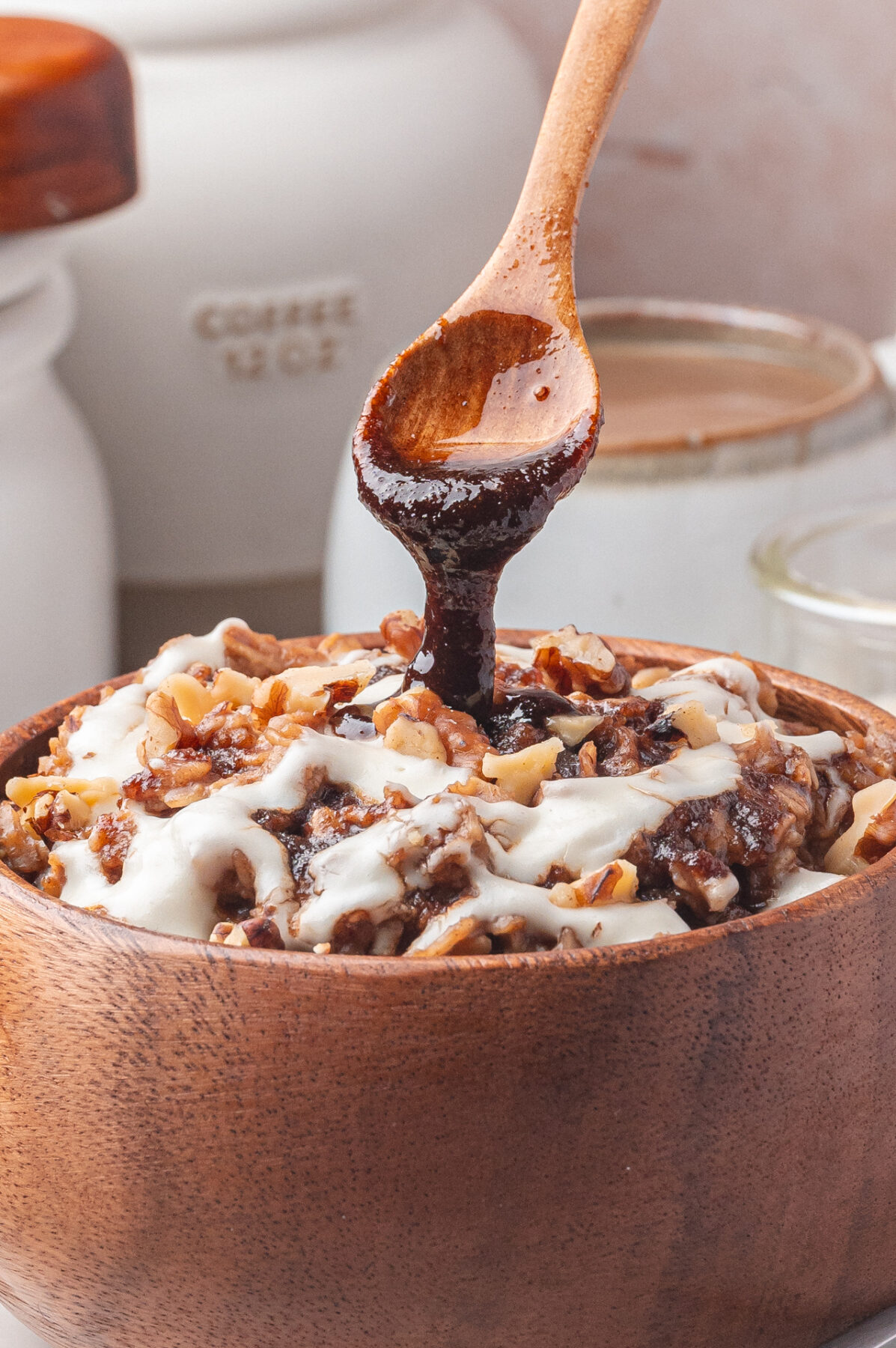 Drizzling cinnamon syrup onto a bowl of oatmeal. 