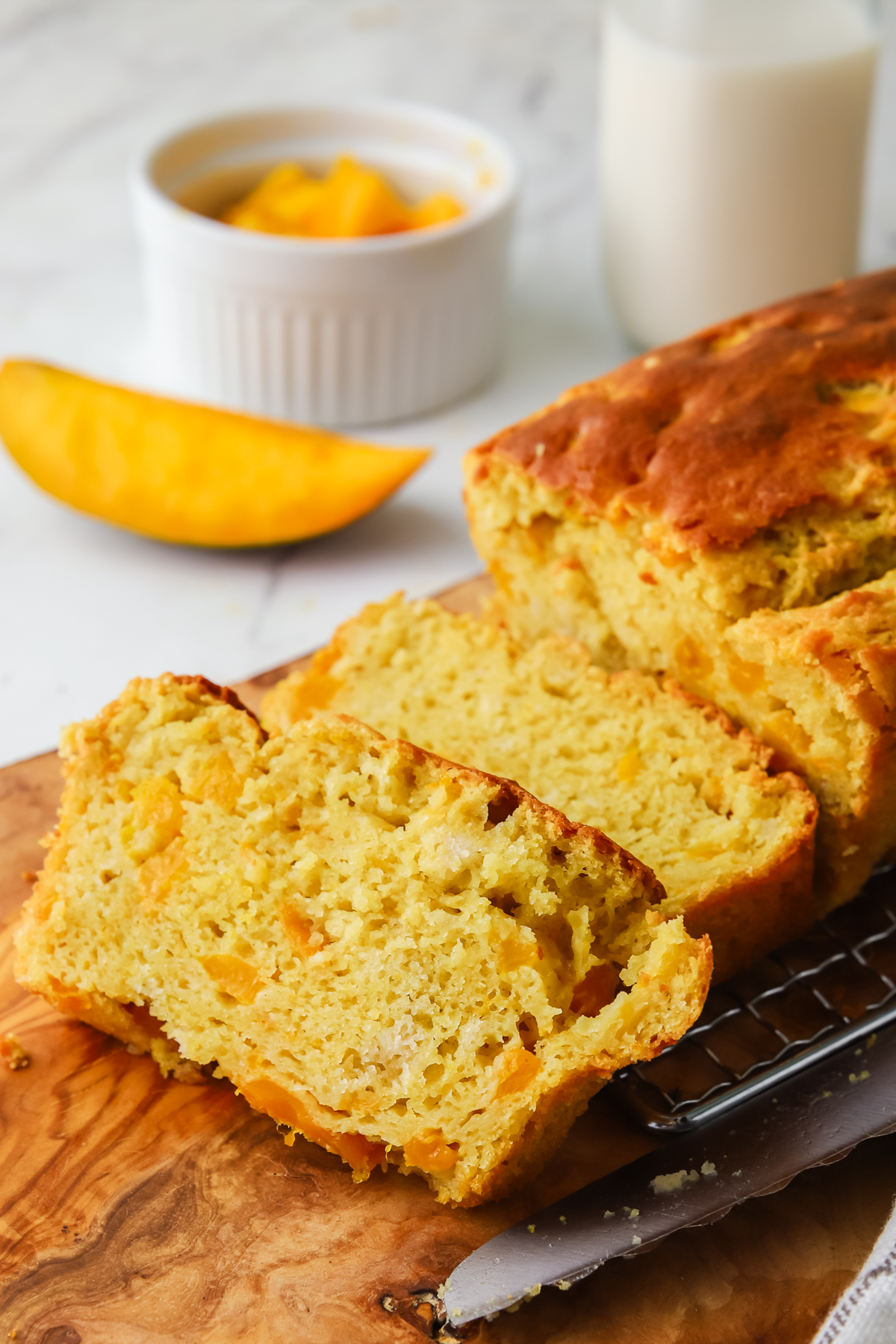 Sliced mango bread on a serving board. 
