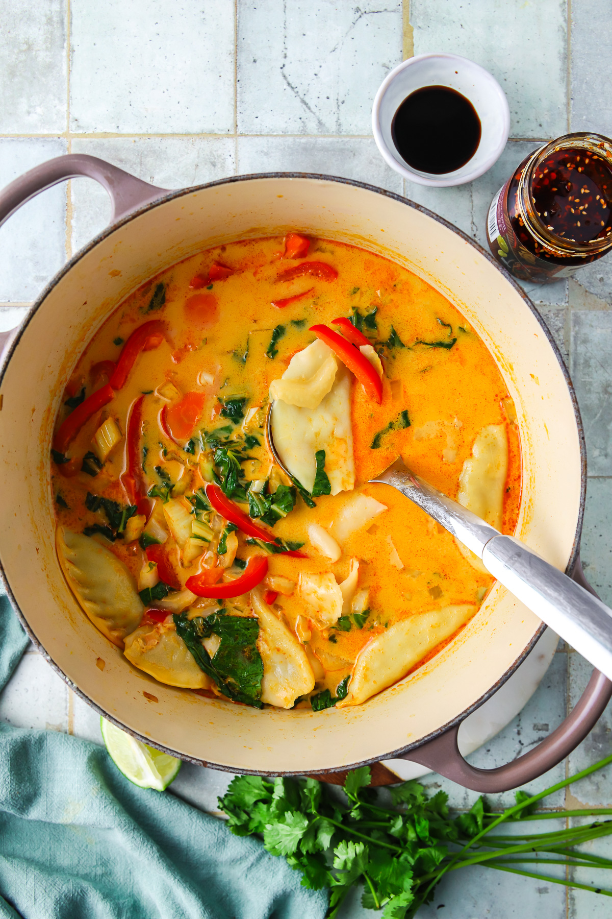 A large pot of coconut curry soup with potstickers. 