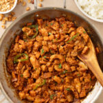 Overhead view of peanut butter chicken stir fry in a stainless pan.