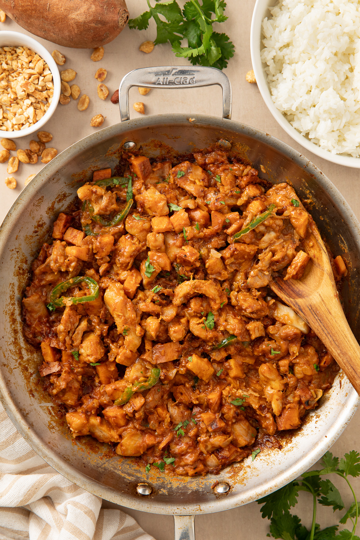 Overhead view of peanut butter chicken stir fry in a stainless pan.