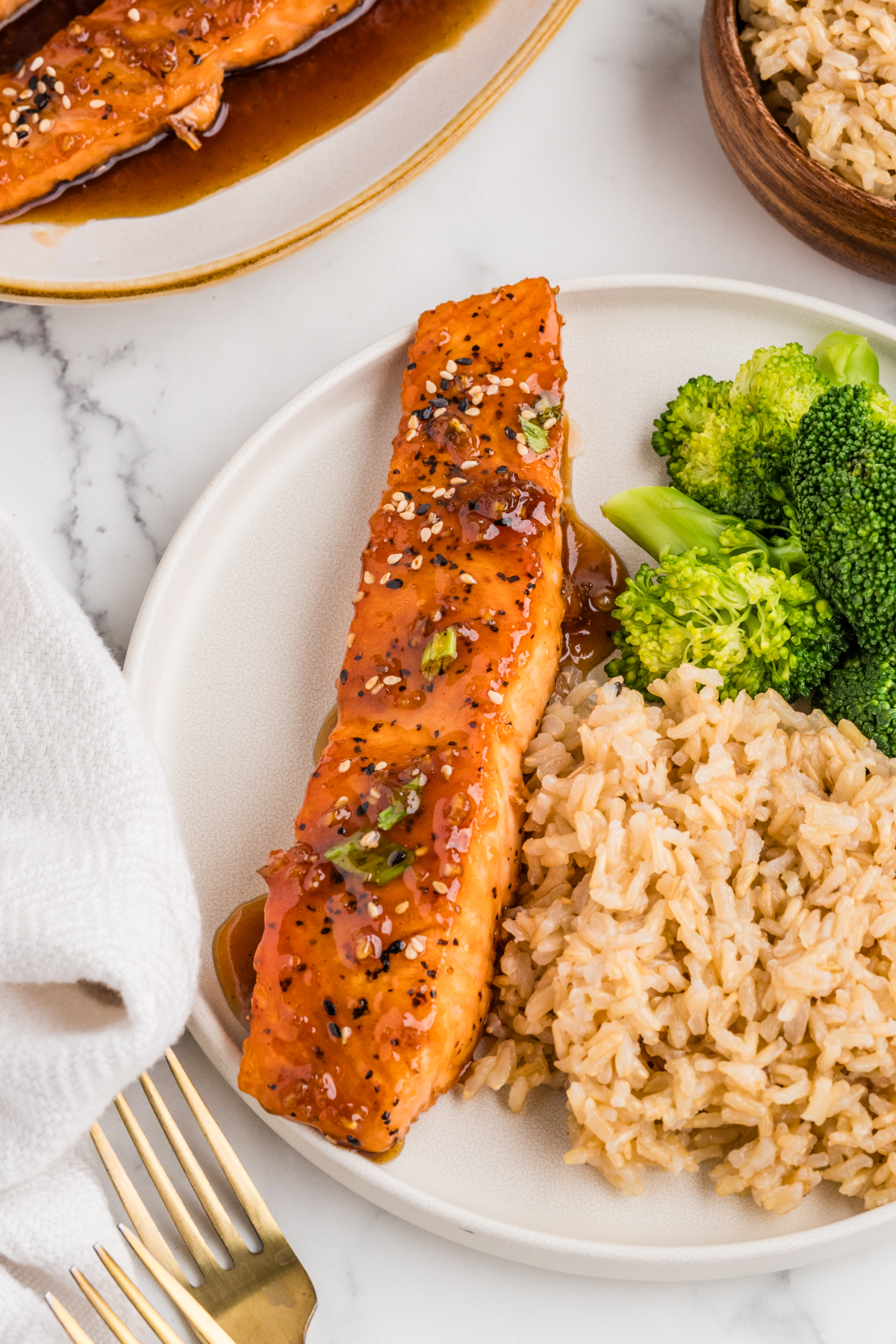 Maple Glazed salmon with rice and broccoli ona white plate.